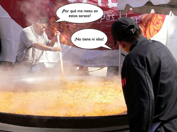 Hombre cocinando paella gigante